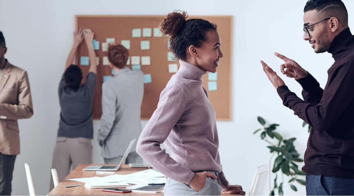 Two team members talking in office space.